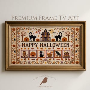 May include: A rectangular gold-toned frame containing a cross-stitch style digital print with the text HAPPY HALLOWEEN. The design features a haunted house, black cats, pumpkins, an owl, a crow, and candy motifs on a cream-coloured background.