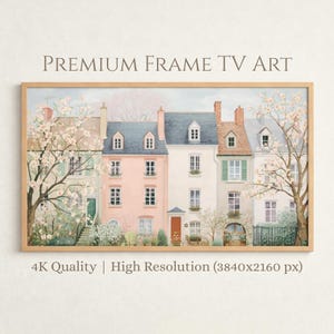 以下が含まれることがあります： 色とりどりのタウンハウスが並び、桜が咲く風景を描いたフレームプリント。家々はパステルカラーで塗装され、窓やドアなどの詳細が描かれています。「PREMIUM FRAME TV ART」の文字が上部にあります。