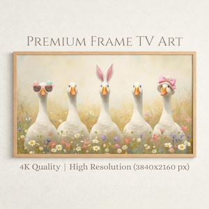Peut inclure: Une impression encadrée représentant cinq oies blanches dans un champ de fleurs sauvages. Les oies sont ornées d'accessoires tels que des lunettes de soleil, des oreilles de lapin et un nœud rose. Le texte "PREMIUM FRAME TV ART" et "4K Quality | High Resolution (3840x2160 px)" sont affichés.
