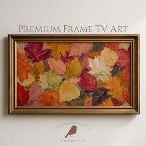 May include: A rectangular framed digital artwork titled PREMIUM FRAME TV ART featuring an oil painting style composition of overlapping autumn leaves in shades of red, orange, yellow, and brown, enclosed in a metallic gold-toned frame.