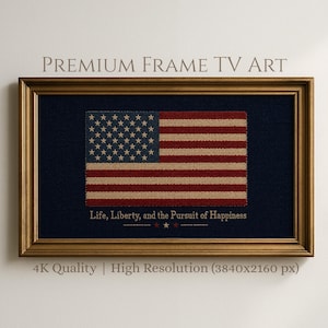 May include: Framed artwork featuring a textured American flag design with red and beige stripes, blue field with white stars, and the text "Life, Liberty, and the Pursuit of Happiness." The frame is gold-colored.