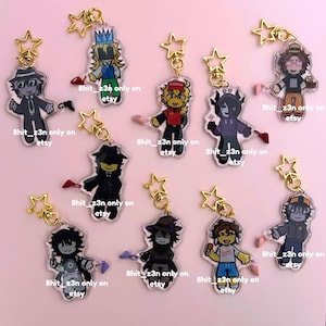 Puede incluir: Una colección de llaveros acrílicos con personajes de dibujos animados con varios atuendos y accesorios. Cada llavero tiene un cierre dorado en forma de estrella y el texto "8hit_z3n only on etsy".