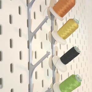 Può includere: Un set di tre tazze in ceramica con finitura opaca e macchiettata. Le tazze sono nei toni del crema, grigio chiaro e grigio scuro. Ogni tazza ha un design semplice e minimalista.