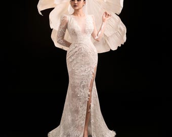 Vestido de novia de sirena con cuello alto y encaje, abertura en la manga y cola larga.