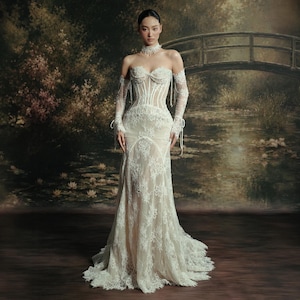 May include: A floor-length strapless gown featuring a structured corset bodice with vertical boning, an intricate white lace overlay, and matching detachable lace sleeves. The dress has a sweetheart neckline and a fitted silhouette that flares slightly.