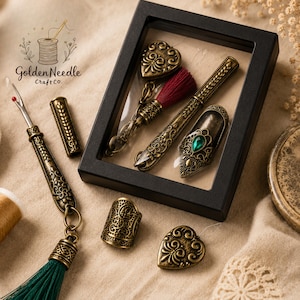 The antique gold set in its black floating frame display gift box with the heart threader, covered seam ripper and jeweled thimble