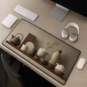 May include: A large rectangular desk mat featuring a printed graphic of various ceramic tea vessels, including a teapot, cups, and a bottle, arranged on a wooden shelf. The mat has a black border and is placed on a light wood desk with a keyboard, mouse, notebook, and headphones.