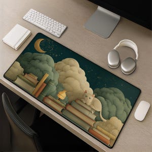 May include: A rectangular desk mat featuring a dark night sky with a crescent moon and stars, large textured green and beige clouds, stacks of books, and a small cream-colored cat resting on top of the books. The mat has a black border.