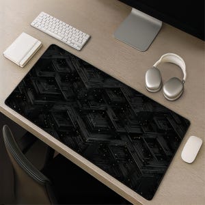 May include: A rectangular desk mat featuring a black and dark grey geometric pattern of intersecting lines and small dots. The mat has a smooth surface with a black border and is positioned on a light wood desk surface with computer accessories.