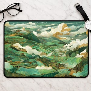 May include: A rectangular mousepad featuring a landscape design with green terraced fields, mountains, and clouds in shades of green, gold, and teal. The mousepad has a black border.