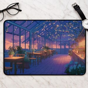 May include: A rectangular desk mat featuring an illustration of a greenhouse interior at sunset. The scene includes wooden tables and chairs, potted plants, and string lights hanging from the glass ceiling, all set against a purple and orange sky.