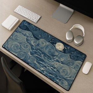 May include: A rectangular desk mat featuring a dark blue and cream-colored swirling pattern that resembles turbulent waves or clouds, with a prominent circular moon-like shape on the right side, all enclosed by a thin black border.
