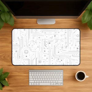 May include: A rectangular desk mat featuring a white background with a detailed black printed pattern of electronic circuit board pathways, lines, and circular nodes. The mat has rounded corners and a thin black border surrounding the entire design.