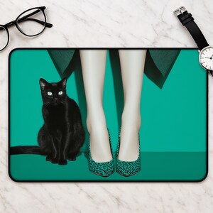 May include: A rectangular mouse pad featuring a vibrant teal background with a black cat sitting on the left side and a pair of legs wearing teal and black leopard print high-heeled pumps positioned in the centre of the frame.