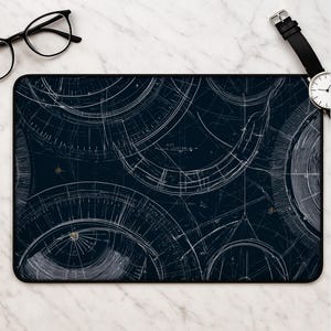 May include: A rectangular desk mat featuring a dark navy blue background with a white technical line drawing pattern of overlapping circular geometric shapes, arcs, and fine grid lines resembling an intricate architectural or engineering blueprint.