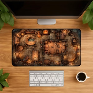 Peut inclure: Un tapis de souris rectangulaire avec une illustration détaillée, vue de dessus, d'une taverne fantastique. Le design comprend des tables en bois, une cheminée et diverses pièces, toutes éclairées d'une lumière chaleureuse. Un clavier et une tasse de café sont visibles.