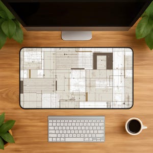 Könnte beinhalten: Eine rechteckige Schreibtischunterlage mit einem beigen und weißen Architekturplan-Design, das feine schwarze Linien, geometrische Formen und technische Zeichnungsdetails aufweist. Die Unterlage hat eine glatte Oberfläche und einen schwarzen Rand.