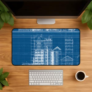 Könnte beinhalten: Eine rechteckige Schreibtischunterlage mit einem detaillierten architektonischen Bauplan-Design in weißen Linien auf tiefblauem Grund. Der Druck zeigt komplexe technische Zeichnungen von mehrstöckigen Gebäuden, einschließlich Fassaden und Dächern.