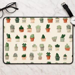 May include: A rectangular desk mat featuring a repeating pattern of various green cacti in different pots against a cream background. The cacti are illustrated in shades of green, while the pots are rendered in terracotta, grey, and white tones.