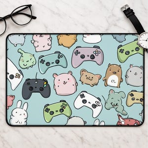 May include: A rectangular desk mat featuring a light blue background with a repeating pattern of various colourful video game controllers and cute, stylised cartoon animals including rabbits, hamsters, and small creatures with simple facial features.