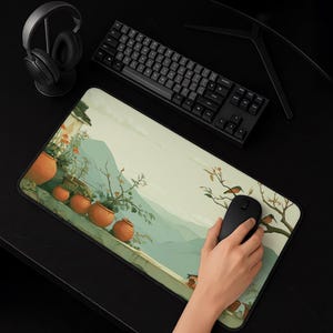 May include: A rectangular desk mat featuring a printed illustration of terracotta pots with plants on a ledge, set against a backdrop of green hills. The mat is positioned on a black surface with a black mechanical keyboard and headphones.