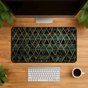 Könnte beinhalten: Eine rechteckige Schreibtischunterlage mit einem sich wiederholenden geometrischen Muster aus dunkelgrünen Dreiecken, die mit dünnen goldenen Linien umrandet sind. Das Design erzeugt einen dreidimensionalen Effekt und wirkt strukturiert.
