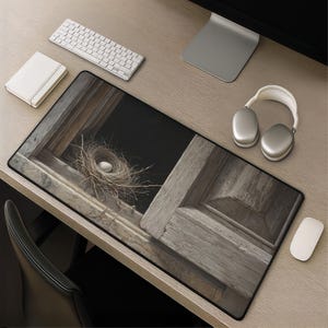 May include: A rectangular desk mat featuring a high-resolution print of a bird nest with a single white egg resting on a weathered wooden window sill. The image displays a dark background behind the nest, contrasting with the textured wood grain.