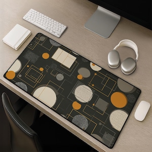Puede incluir: Una alfombrilla de escritorio rectangular con fondo gris oscuro y un patrón geométrico de círculos, cuadrados y líneas finas en tonos naranja, beige y gris. El diseño incluye elementos circulares texturizados y formas sólidas dispuestas.