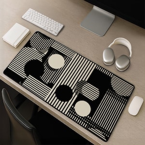 Puede incluir: Una alfombrilla de escritorio rectangular con un patrón gráfico de alto contraste de rayas verticales blancas y negras, círculos negros sólidos y círculos de color blanco roto dispuestos en una composición geométrica en toda la superficie de la alfombrilla.
