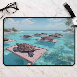 May include: A rectangular desk mat featuring a digital illustration of multiple sea turtles resting on individual pink wooden platforms floating in clear turquoise ocean water, with a tropical island coastline visible in the background.