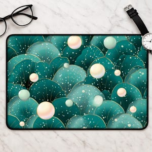 May include: A rectangular mousepad featuring a teal and gold abstract design. The design includes overlapping leaf-like shapes with white speckles and floating spheres in shades of cream and green. The mousepad has a black border.