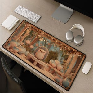 May include: A rectangular desk mat featuring a printed illustration of a small, round hedgehog sitting on a wooden bench within a garden setting. The scene includes several ceramic pots and soft, warm-toned foliage under a wooden pergola structure.