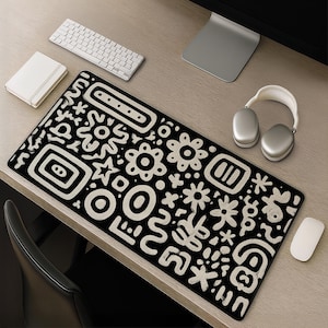 Black and white folk doodle desk mat with bold frames, flowers, stars, dots, ovals and abstract symbols in hand drawn linework
