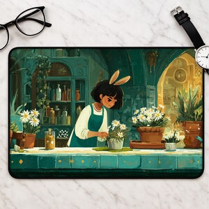May include: A rectangular desk mat featuring an illustration of a person with rabbit ears wearing a green apron, tending to potted white daisy plants on a teal counter. The background shows a dark green shelf filled with various glass bottles.