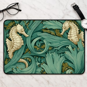 May include: A rectangular desk mat featuring a repeating pattern of two golden seahorses amidst swirling teal and green aquatic foliage. The design is detailed with intricate linework, showcasing the textured scales of the seahorses.