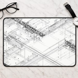 May include: A rectangular desk mat featuring a detailed black and white architectural blueprint design with intricate line work, geometric structures, and technical floor plan elements, finished with a clean black border edge.