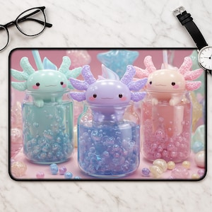 May include: Three colorful axolotl figures sit atop glass jars filled with liquid and bubbles. The axolotls are pastel shades of green, purple, and pink, with matching liquid in the jars. The jars are arranged on a pink surface with scattered decorative elements.