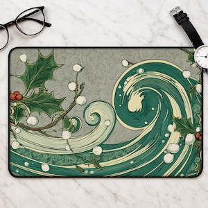 May include: A rectangular desk mat featuring a stylized graphic illustration of a swirling green wave intertwined with holly branches, green leaves, red berries, and white berries against a textured gray background with fine swirling line patterns.