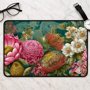 May include: Rectangular mouse mat with a colourful floral design. The design features large pink and white flowers, red and yellow textured blooms, and green foliage against a teal paisley background. The mouse mat has a black border.