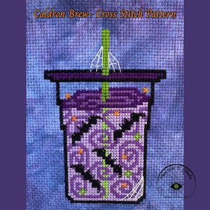 May include: Cross-stitch pattern depicting a purple cauldron brew drink with black bats, orange stars, and a green straw. The text "Caldron Brew - Cross Stitch Pattern" is at the top. The background is a blue cross-stitch fabric.