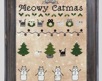 May include: Cross-stitch art in a distressed wooden frame. The design features the text "Meowy Catmas" above cat-themed Christmas motifs, including cats, wreaths, Christmas trees, and snowmen. The color palette includes green, black, white, and tan.