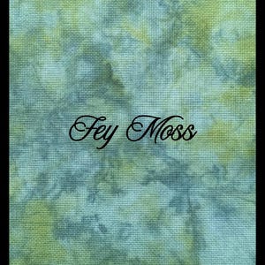May include: A piece of fabric with a tie-dye pattern in shades of green, blue, and teal. The fabric has a visible woven texture and features the text Fey Moss printed in a black, cursive, decorative font across the center of the image.