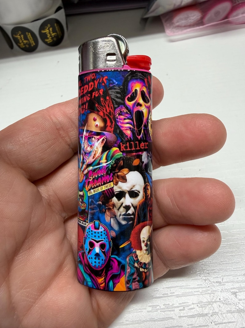 Peut inclure: Un briquet cylindrique pr&eacute;sentant un collage color&eacute; de personnages de films d'horreur, notamment Freddy Krueger, Ghostface, Michael Myers, Jason Voorhees et Pennywise. Le design inclut des textes comme Two, Freddy's coming for you, killer et Sweet dreams are made of these.