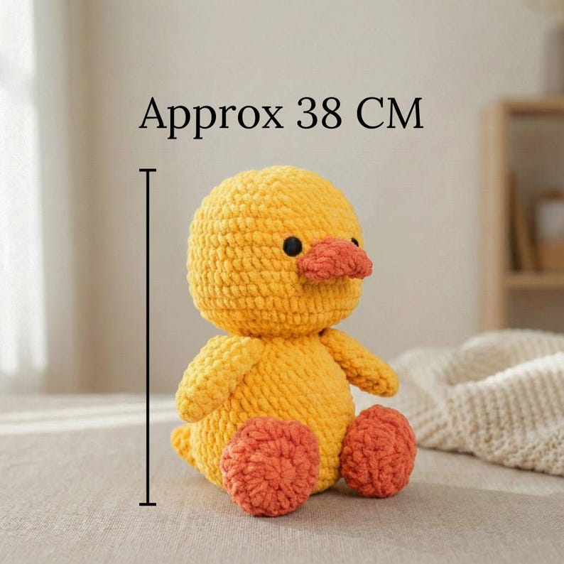 Large amigurumi duck crochet pattern finished sample in soft butter yellow with peach beak and coral feet sitting on a neutral linen backdrop, close up of stitches and shaping to show texture; handmade plush toy photographed to illustrate finished size (about 38 cm tall); pattern PDF includes step-by-step rounds, materials, and assembly photos for beginners and intermediate crocheters.