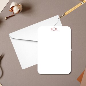 May include: A white card with rounded corners and a red monogram "ROL" in the top center.