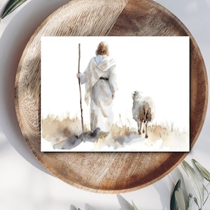 May include: Watercolor art print depicting a figure in white robes holding a staff, walking with a sheep. The artwork features soft, muted colors and a serene landscape with subtle brown and beige tones, evoking a sense of peace and spirituality.