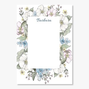 May include: A white stationery sheet with a floral border. The border features white, light blue, and pink flowers with green leaves. The name "Barbara" is written in a script font.