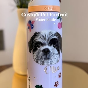 May include: A white ceramic mug with a black handle and the text "But First, Coffee" in a bold, black font. The mug is set against a blurred background, suggesting a cozy setting.