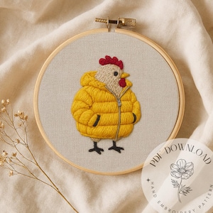 Puede incluir: Pollo bordado a mano con una chaqueta acolchada amarilla, cosido sobre una tela beige dentro de un bastidor de bordado de madera. El pollo tiene una cresta roja y patas negras. Una pegatina de descarga PDF está en la esquina inferior derecha.