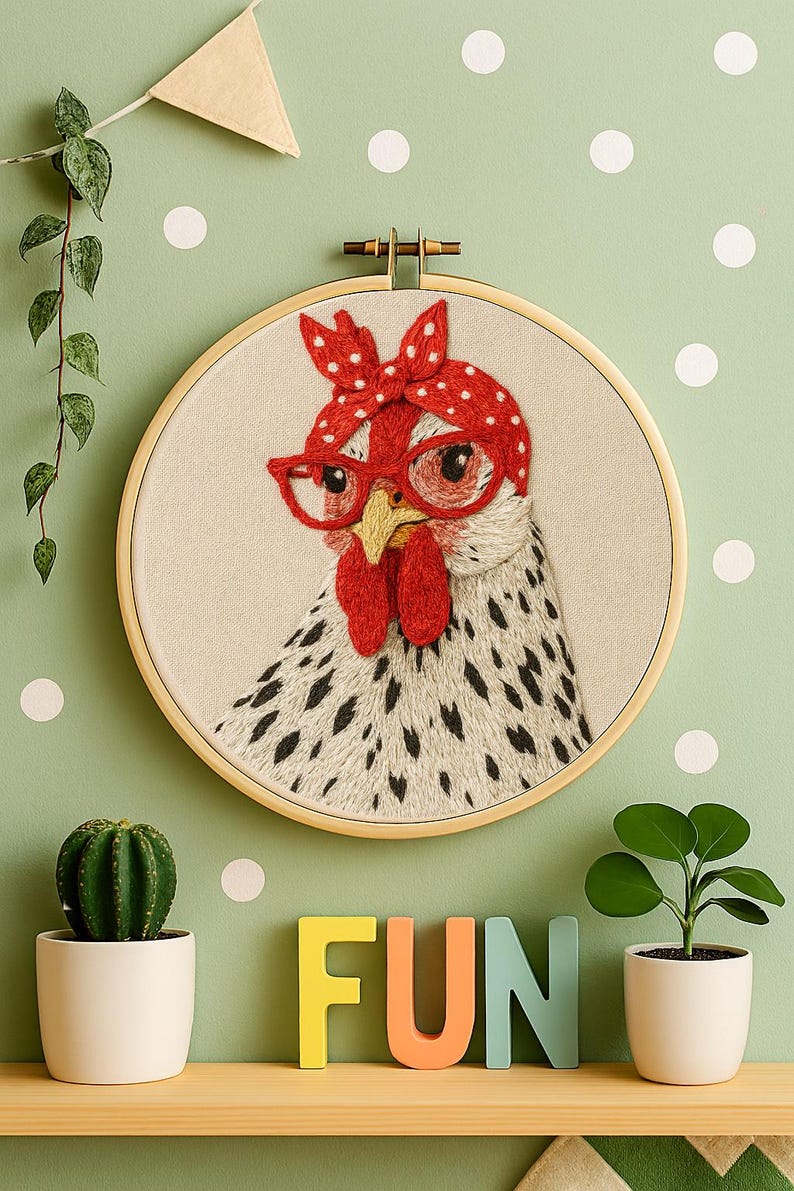 May include: A circular wooden embroidery hoop containing a fabric panel with a stitched illustration of a white chicken with black speckles. The chicken wears red-rimmed glasses and a red headscarf with white polka dots on its head.
